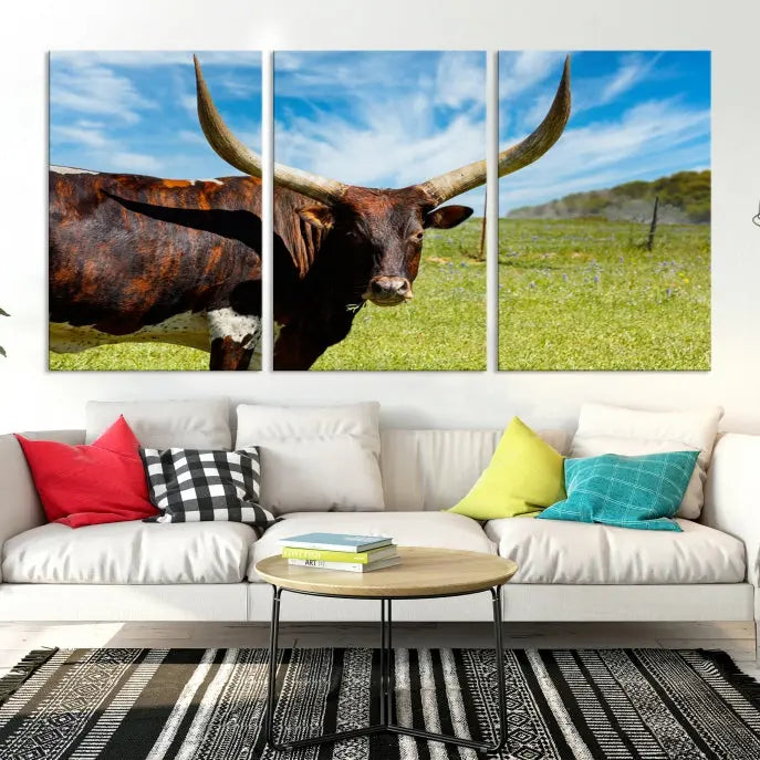 The Texas Longhorn Cow Wall Art Animal Canvas Print is a three-panel portrayal of a longhorn cow in a grassy field on museum-quality canvas with UV-protective coating.