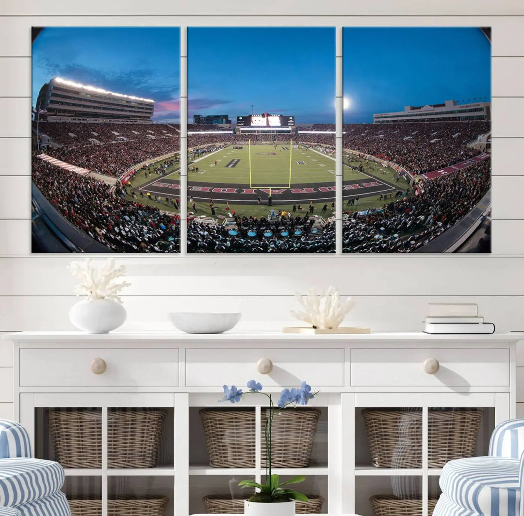 A gallery-quality triptych canvas of the Texas Tech Red Raiders football team print, showcasing Lubbock's Jones AT&T Stadium at twilight from the end zone, hangs on the wall. This stunning piece of wall art canvas print is handmade in the USA, elevating any space with its dynamic and immersive presence.