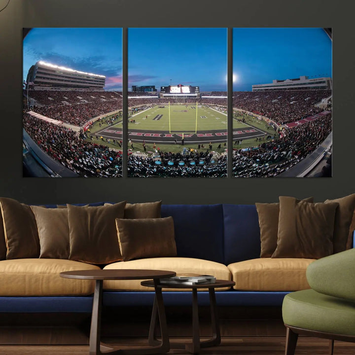 A gallery-quality triptych canvas of the Texas Tech Red Raiders football team print, showcasing Lubbock's Jones AT&T Stadium at twilight from the end zone, hangs on the wall. This stunning piece of wall art canvas print is handmade in the USA, elevating any space with its dynamic and immersive presence.