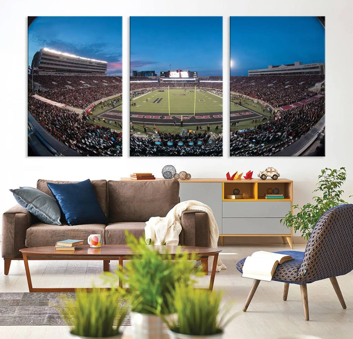 A gallery-quality triptych canvas of the Texas Tech Red Raiders football team print, showcasing Lubbock's Jones AT&T Stadium at twilight from the end zone, hangs on the wall. This stunning piece of wall art canvas print is handmade in the USA, elevating any space with its dynamic and immersive presence.