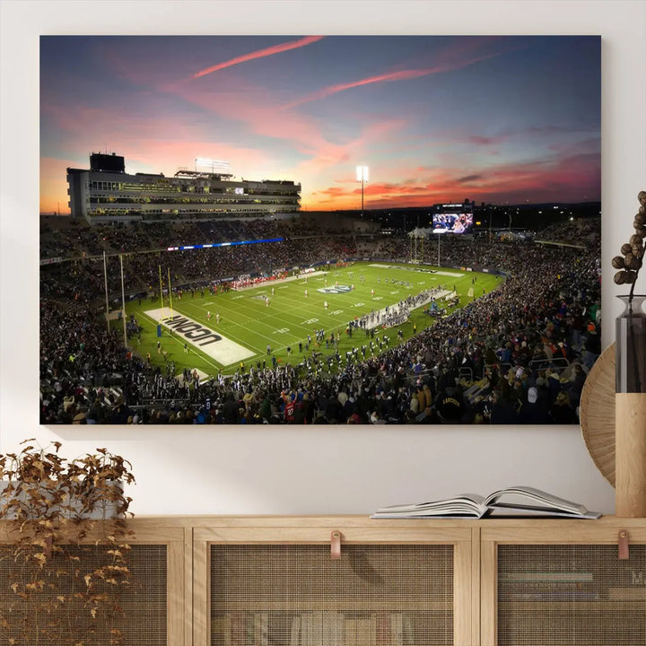 The living room is highlighted by a stunning triptych of the University of Connecticut UCONN Huskies Football Team at sunset on premium canvas, showcasing the East Hartford Pratt & Whitney Stadium.