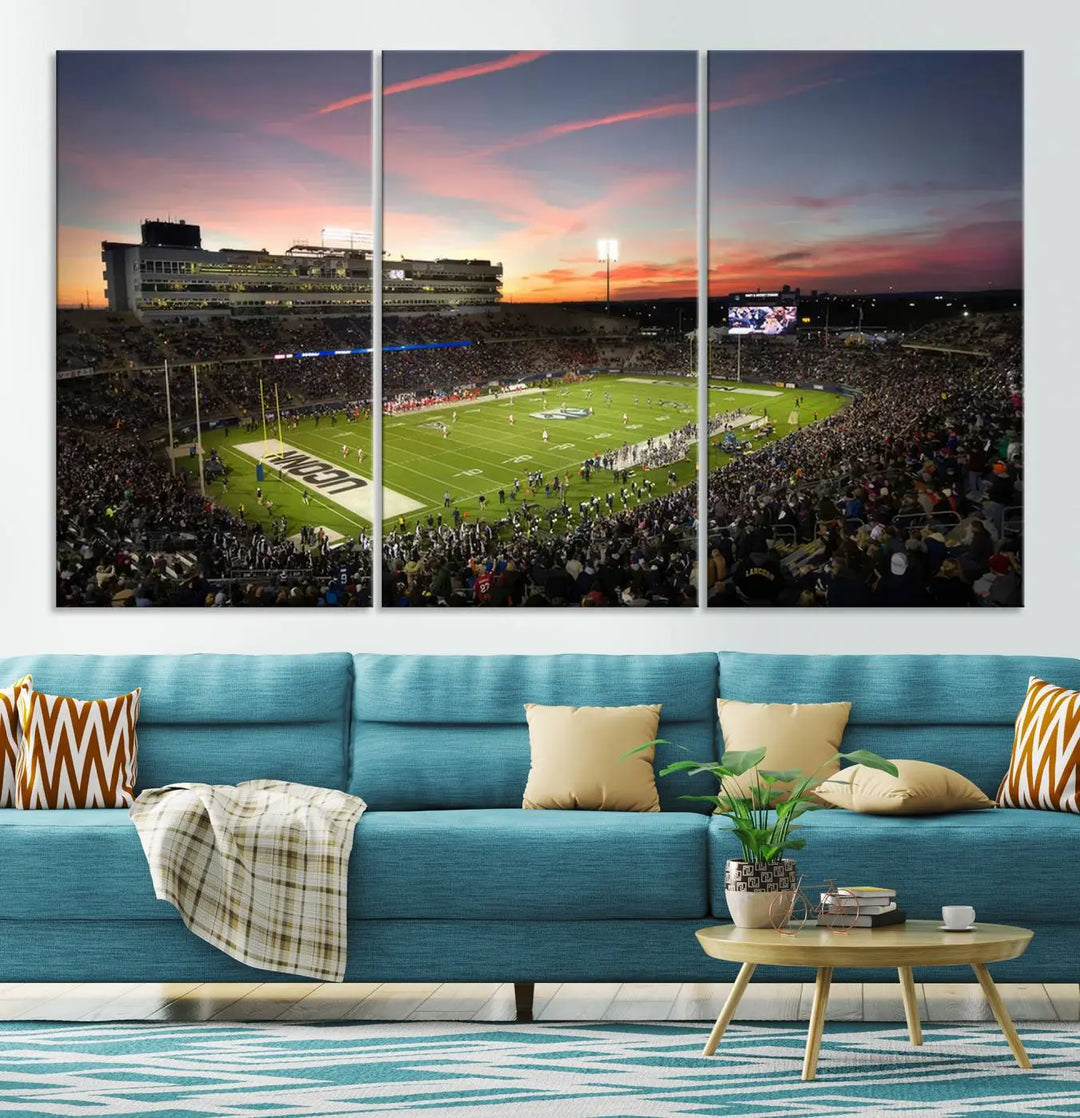 The living room is highlighted by a stunning triptych of the University of Connecticut UCONN Huskies Football Team at sunset on premium canvas, showcasing the East Hartford Pratt & Whitney Stadium.