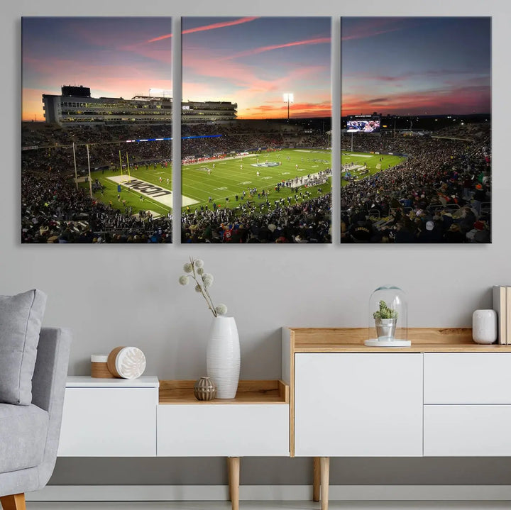 The living room is highlighted by a stunning triptych of the University of Connecticut UCONN Huskies Football Team at sunset on premium canvas, showcasing the East Hartford Pratt & Whitney Stadium.