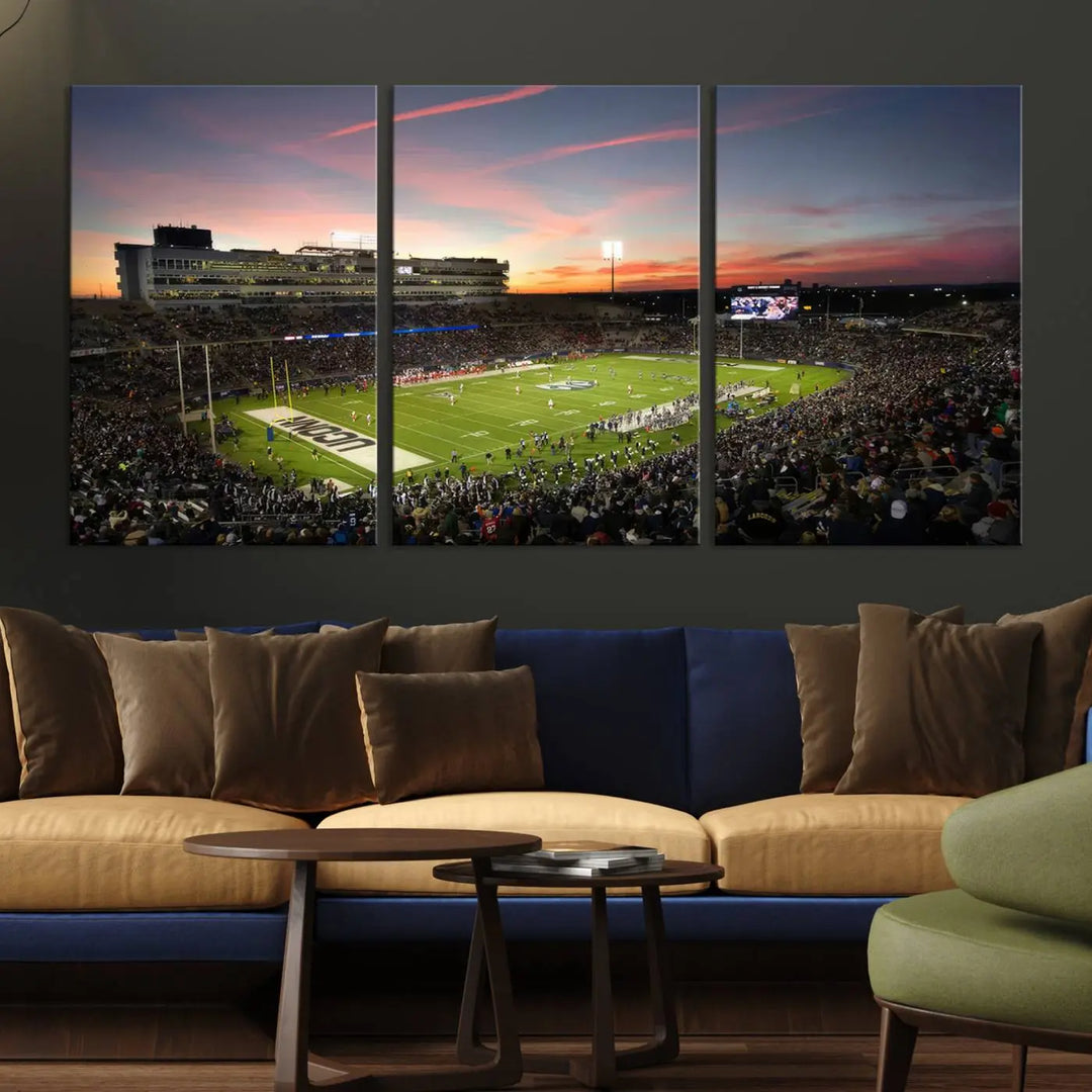 The living room is highlighted by a stunning triptych of the University of Connecticut UCONN Huskies Football Team at sunset on premium canvas, showcasing the East Hartford Pratt & Whitney Stadium.