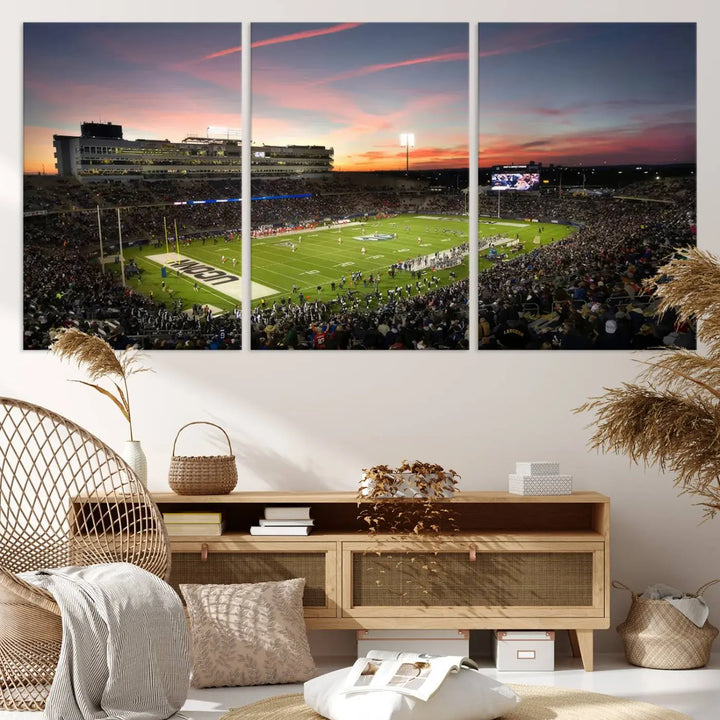 The living room is highlighted by a stunning triptych of the University of Connecticut UCONN Huskies Football Team at sunset on premium canvas, showcasing the East Hartford Pratt & Whitney Stadium.