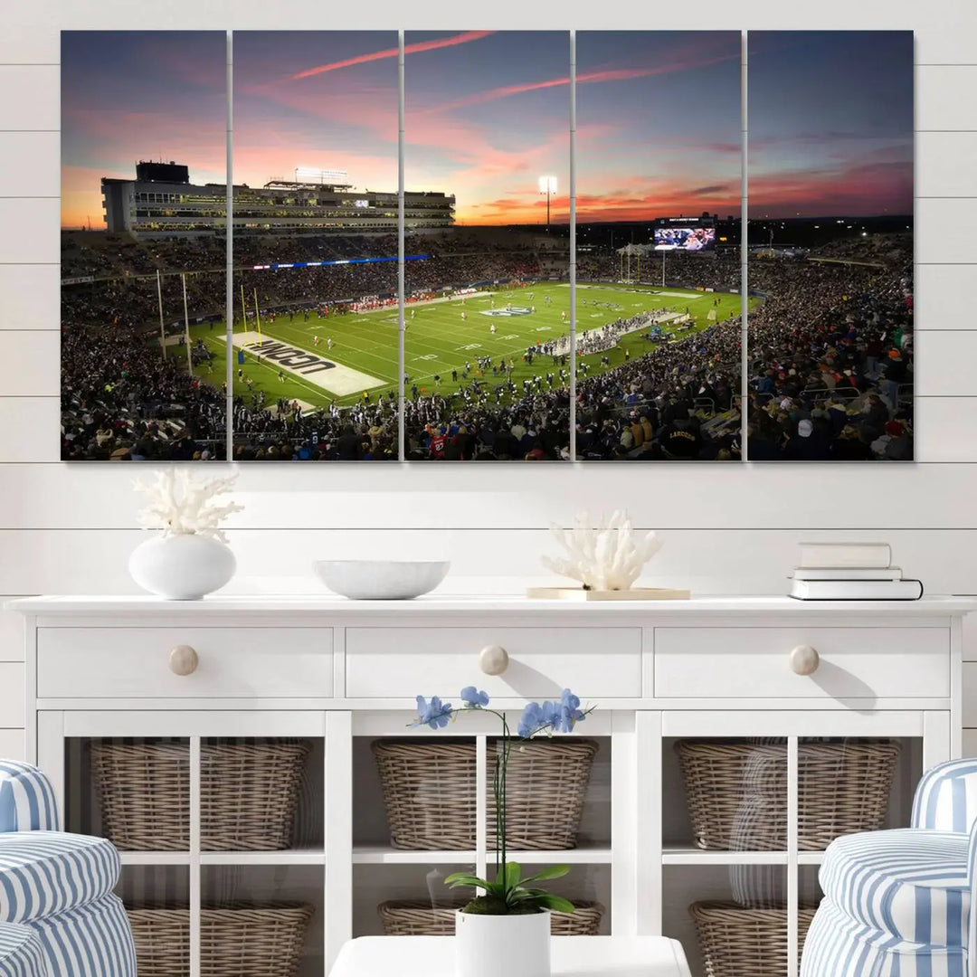 The living room is highlighted by a stunning triptych of the University of Connecticut UCONN Huskies Football Team at sunset on premium canvas, showcasing the East Hartford Pratt & Whitney Stadium.