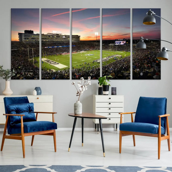 The living room is highlighted by a stunning triptych of the University of Connecticut UCONN Huskies Football Team at sunset on premium canvas, showcasing the East Hartford Pratt & Whitney Stadium.