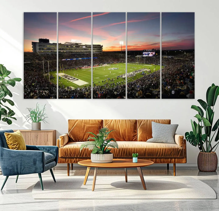 The living room is highlighted by a stunning triptych of the University of Connecticut UCONN Huskies Football Team at sunset on premium canvas, showcasing the East Hartford Pratt & Whitney Stadium.