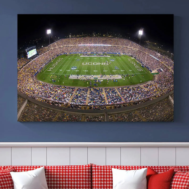 A triptych canvas artwork titled "The University of Connecticut UCONN Huskies Football Team Print" showcases a packed Pratt & Whitney Stadium in East Hartford at night, with a stunning gallery-quality finish.