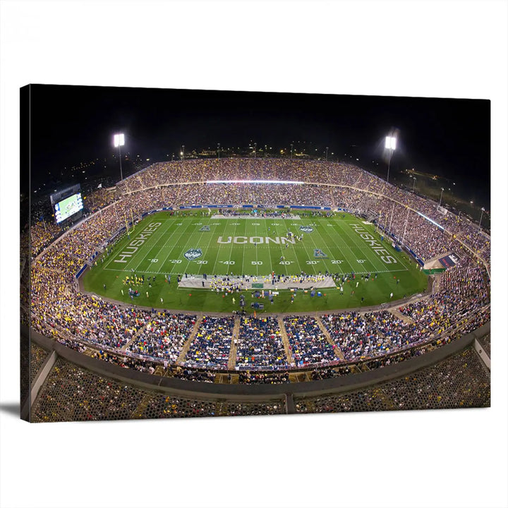 A triptych canvas artwork titled "The University of Connecticut UCONN Huskies Football Team Print" showcases a packed Pratt & Whitney Stadium in East Hartford at night, with a stunning gallery-quality finish.