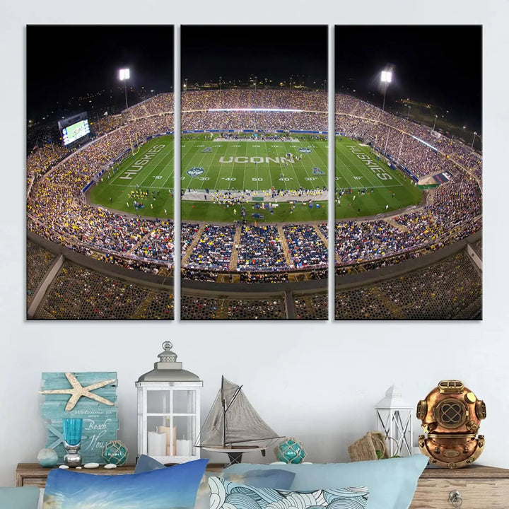 A triptych canvas artwork titled "The University of Connecticut UCONN Huskies Football Team Print" showcases a packed Pratt & Whitney Stadium in East Hartford at night, with a stunning gallery-quality finish.