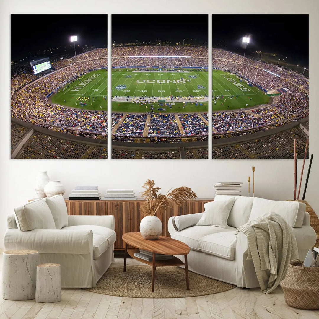 A triptych canvas artwork titled "The University of Connecticut UCONN Huskies Football Team Print" showcases a packed Pratt & Whitney Stadium in East Hartford at night, with a stunning gallery-quality finish.