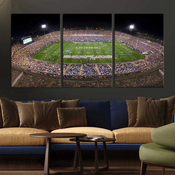 A triptych canvas artwork titled "The University of Connecticut UCONN Huskies Football Team Print" showcases a packed Pratt & Whitney Stadium in East Hartford at night, with a stunning gallery-quality finish.