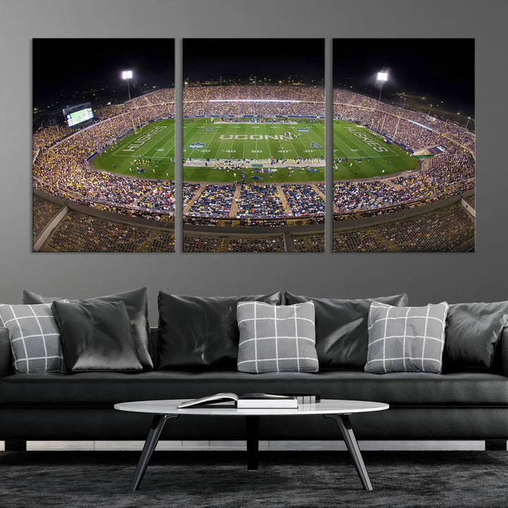 A triptych canvas artwork titled "The University of Connecticut UCONN Huskies Football Team Print" showcases a packed Pratt & Whitney Stadium in East Hartford at night, with a stunning gallery-quality finish.