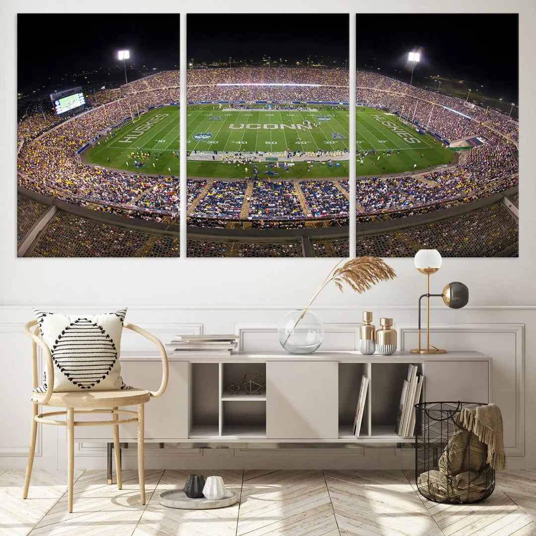 A triptych canvas artwork titled "The University of Connecticut UCONN Huskies Football Team Print" showcases a packed Pratt & Whitney Stadium in East Hartford at night, with a stunning gallery-quality finish.