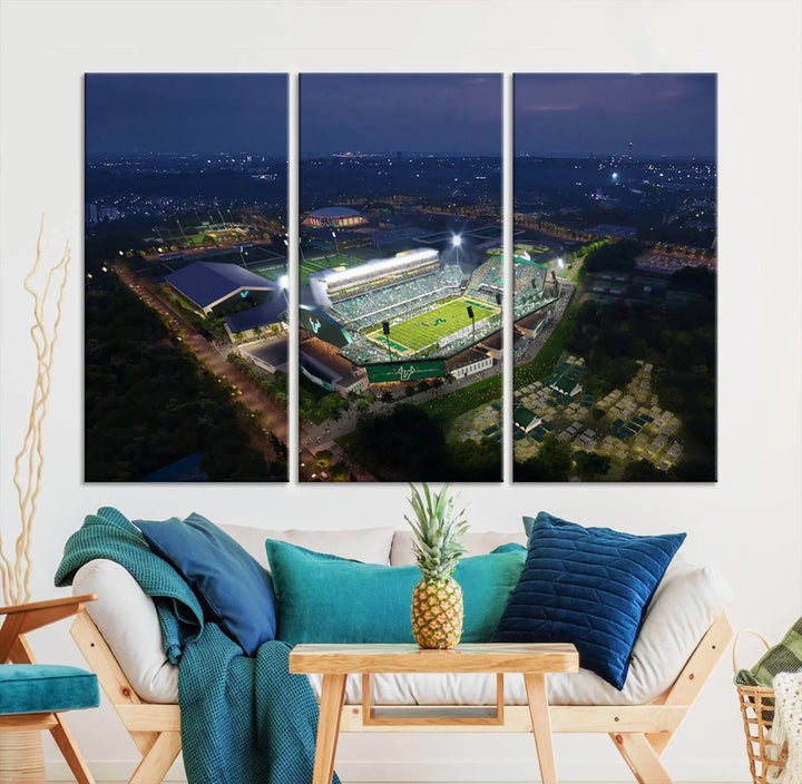 A living room showcasing 'The University of South Florida Bulls Football Team Print' as a triptych wall art highlights the Tampa USF Football Stadium under bright lights at night with a gallery-quality finish.