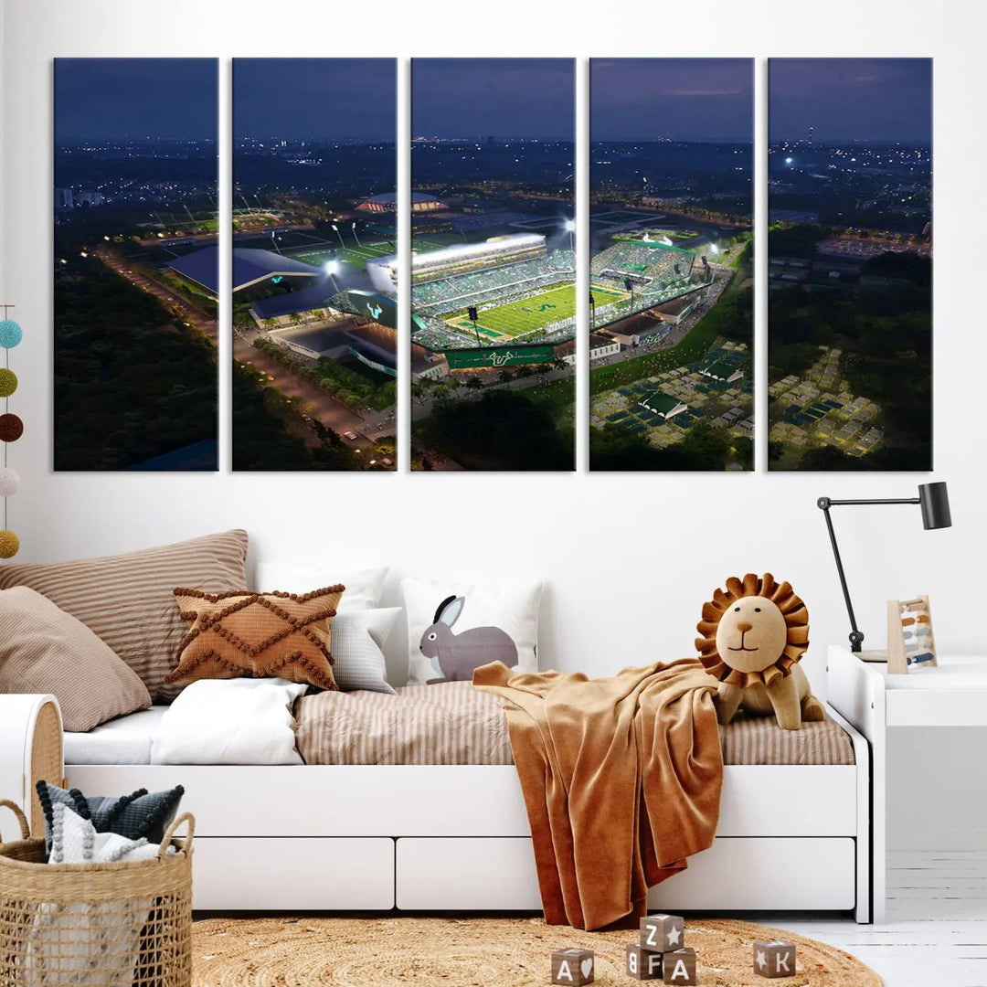 A living room showcasing 'The University of South Florida Bulls Football Team Print' as a triptych wall art highlights the Tampa USF Football Stadium under bright lights at night with a gallery-quality finish.