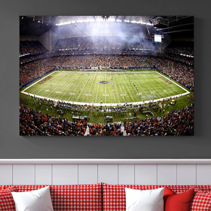 A living room features a striking piece of art on the wall, showcasing high-resolution printing on museum-quality canvas with "The University of Texas at San Antonio Roadrunners Football Team Print - San Antonio Alamodome Wall Art Canvas Print.