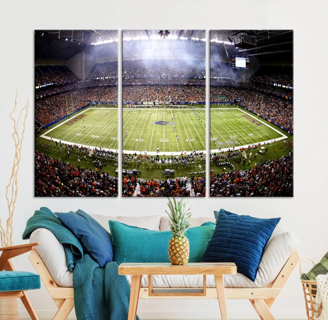 A living room features a striking piece of art on the wall, showcasing high-resolution printing on museum-quality canvas with "The University of Texas at San Antonio Roadrunners Football Team Print - San Antonio Alamodome Wall Art Canvas Print.