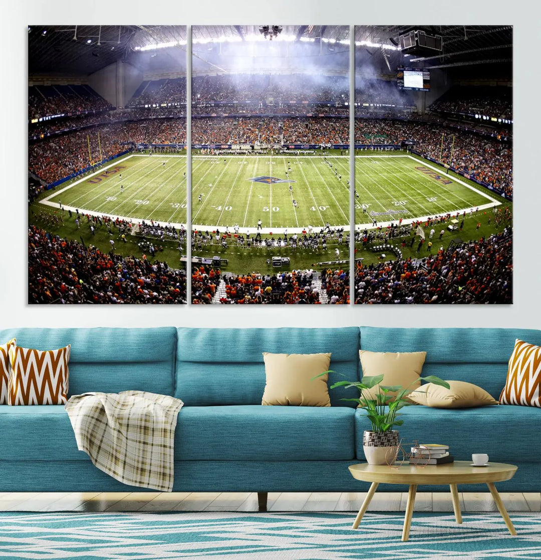 A living room features a striking piece of art on the wall, showcasing high-resolution printing on museum-quality canvas with "The University of Texas at San Antonio Roadrunners Football Team Print - San Antonio Alamodome Wall Art Canvas Print.