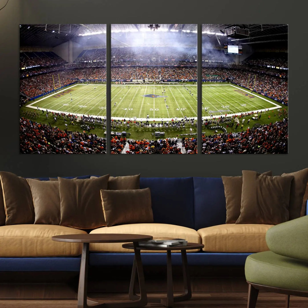 A living room features a striking piece of art on the wall, showcasing high-resolution printing on museum-quality canvas with "The University of Texas at San Antonio Roadrunners Football Team Print - San Antonio Alamodome Wall Art Canvas Print.