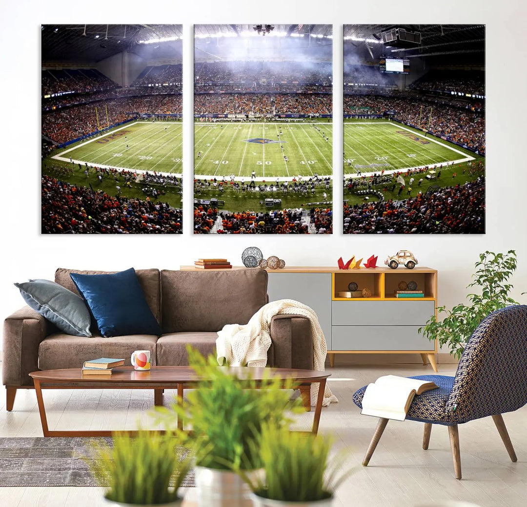 A living room features a striking piece of art on the wall, showcasing high-resolution printing on museum-quality canvas with "The University of Texas at San Antonio Roadrunners Football Team Print - San Antonio Alamodome Wall Art Canvas Print.