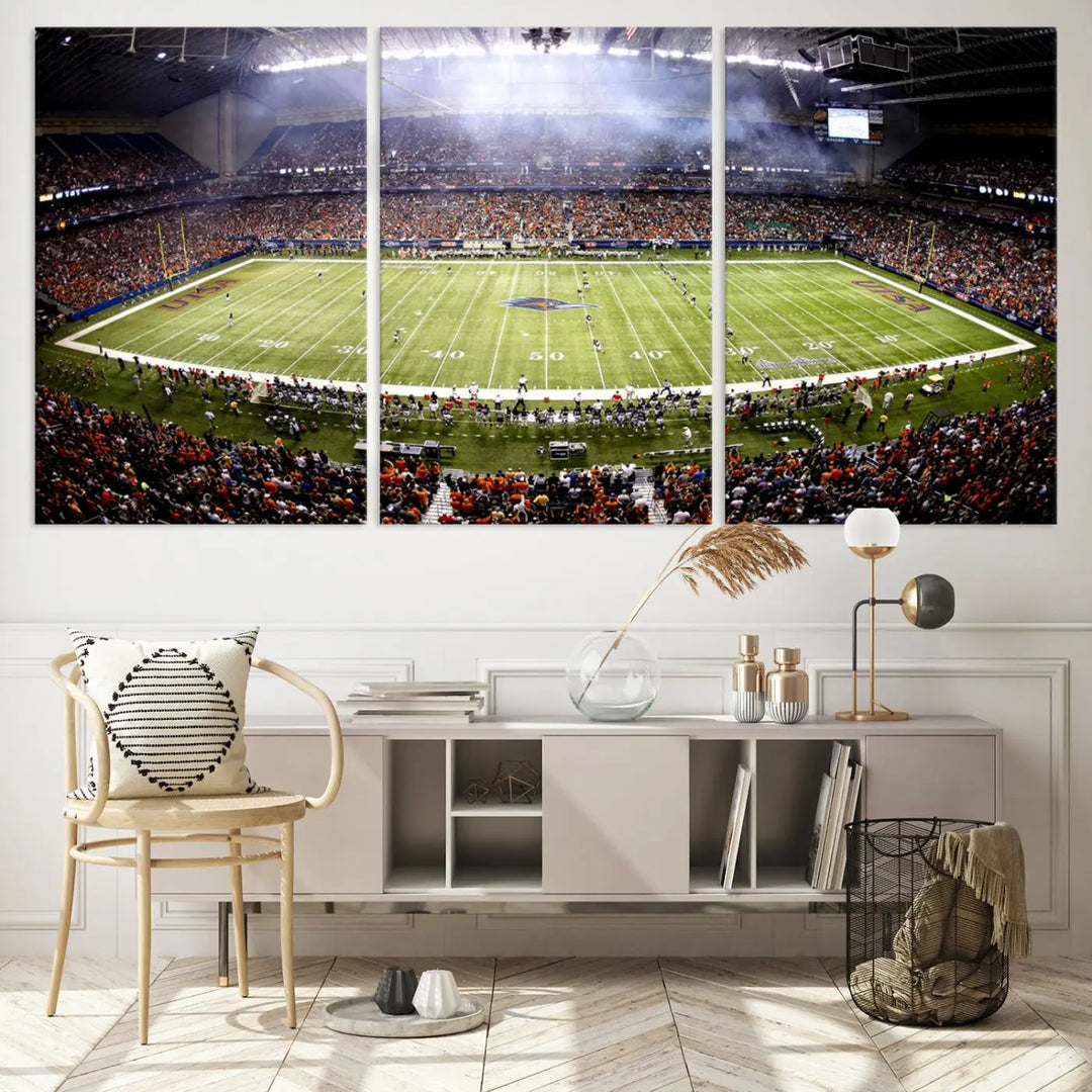 A living room features a striking piece of art on the wall, showcasing high-resolution printing on museum-quality canvas with "The University of Texas at San Antonio Roadrunners Football Team Print - San Antonio Alamodome Wall Art Canvas Print.