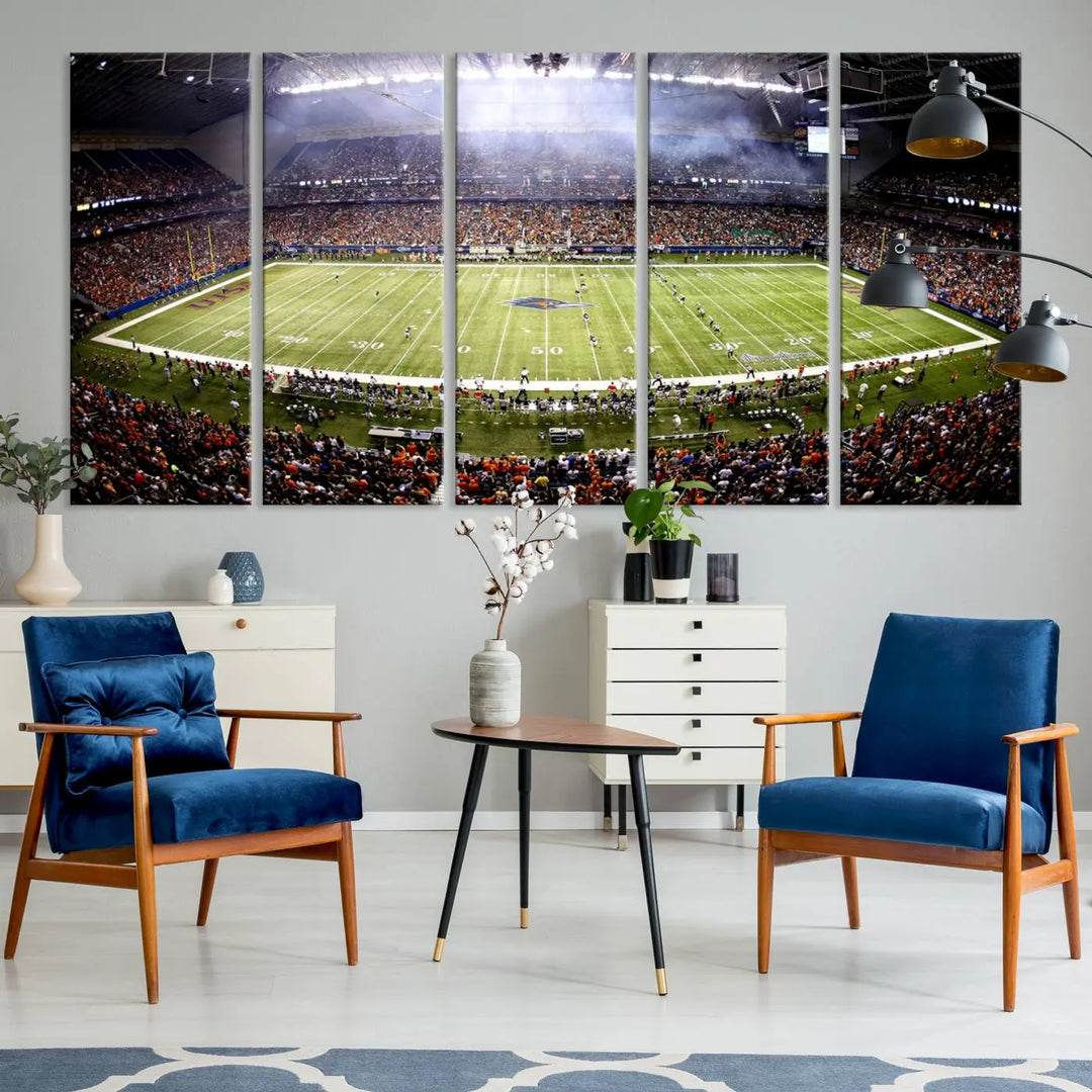 A living room features a striking piece of art on the wall, showcasing high-resolution printing on museum-quality canvas with "The University of Texas at San Antonio Roadrunners Football Team Print - San Antonio Alamodome Wall Art Canvas Print.