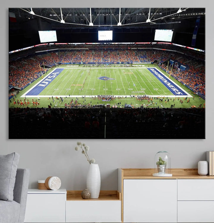 The living room features a large wall art of The University of Texas at San Antonio Roadrunners Football Team, capturing the vibrant atmosphere of the San Antonio Alamodome and printed with museum-quality precision.