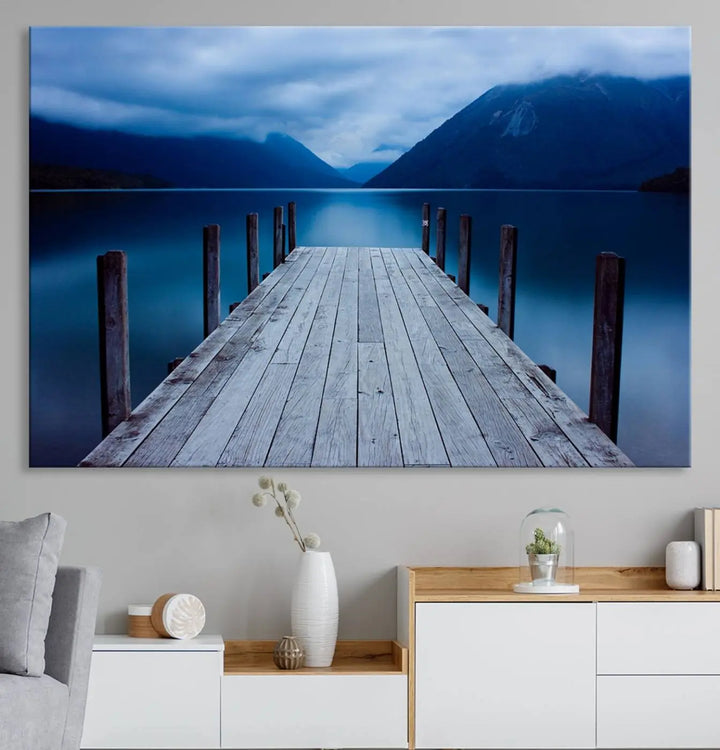 Tranquil lakeside pier triptych canvas art featuring a blue mountain horizon and serene dock. Perfect for modern interiors. High-quality giclee canvas print.