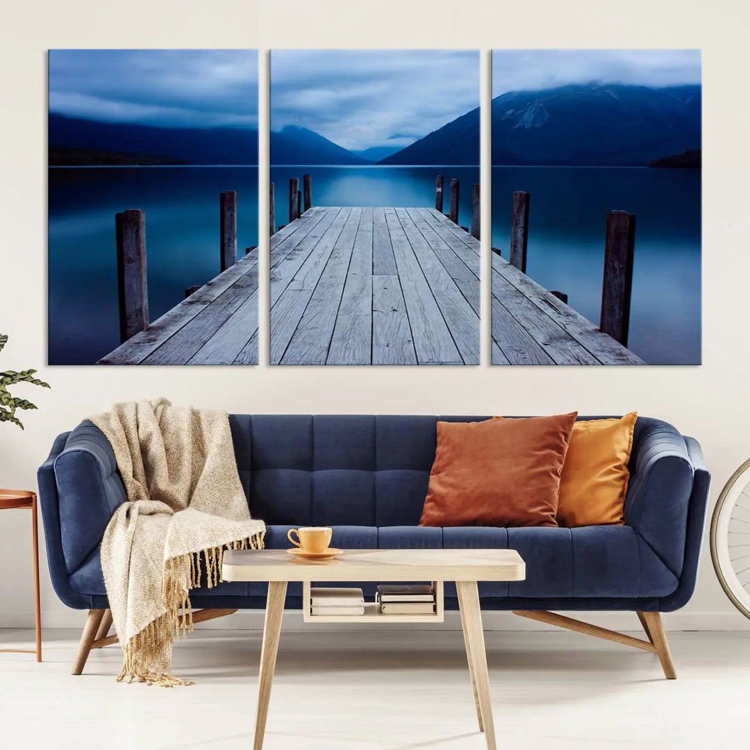 Tranquil lakeside pier triptych canvas art featuring a blue mountain horizon and serene dock. Perfect for modern interiors. High-quality giclee canvas print.