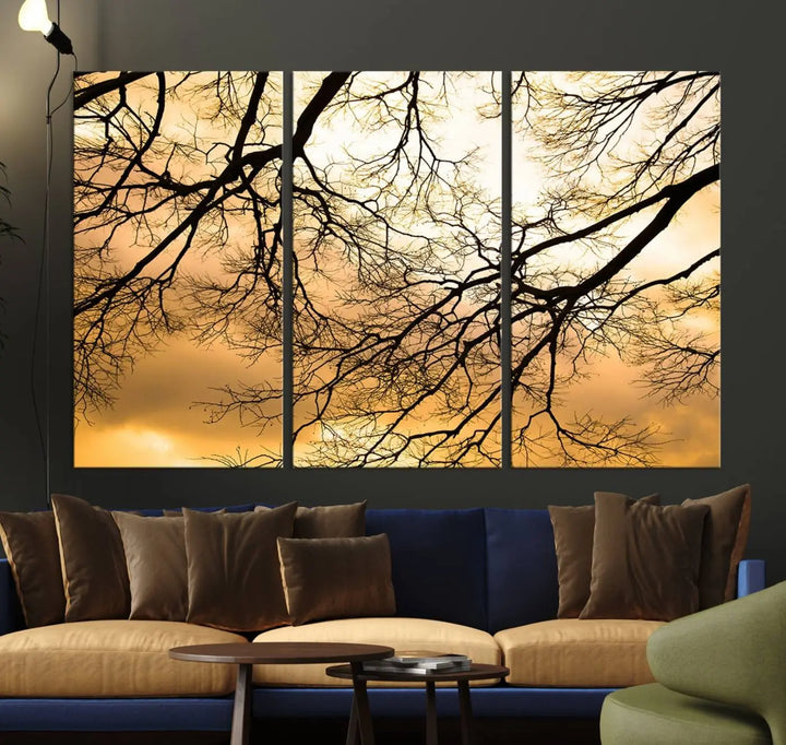 The Tree Branch Wall Art Canvas Print is a triptych depicting tree branches against an orange sky, printed on museum-quality canvases. Each piece comes ready to hang, offering both style and convenience.