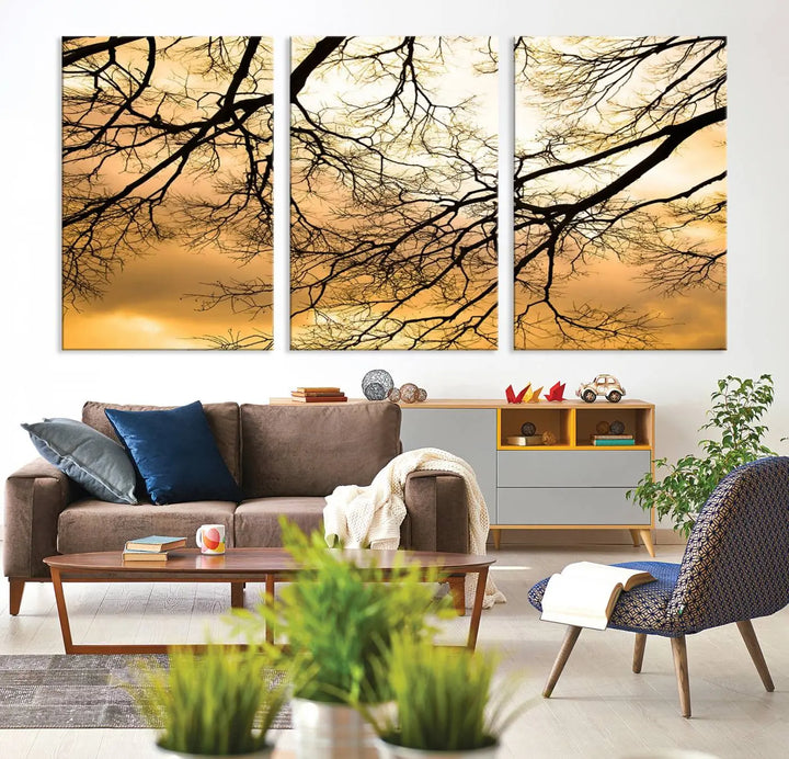 The Tree Branch Wall Art Canvas Print is a triptych depicting tree branches against an orange sky, printed on museum-quality canvases. Each piece comes ready to hang, offering both style and convenience.