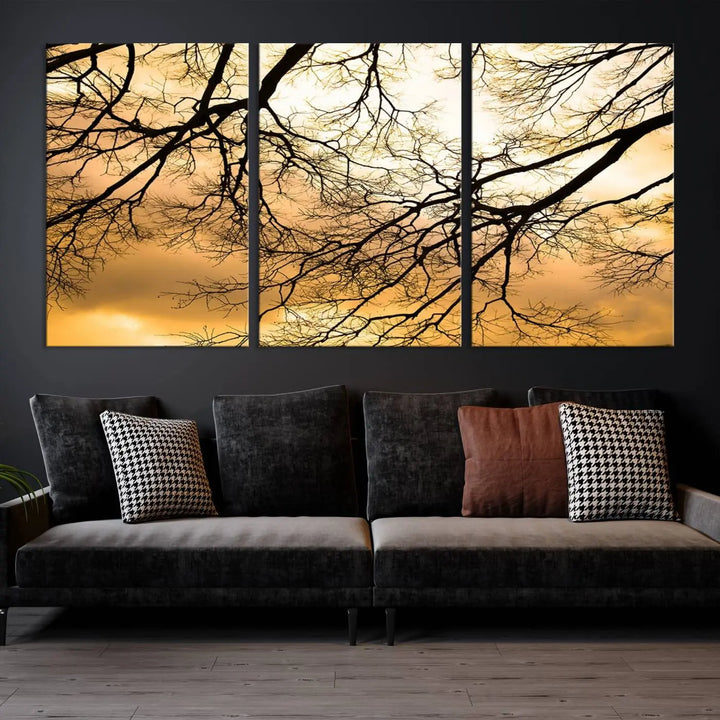 The Tree Branch Wall Art Canvas Print is a triptych depicting tree branches against an orange sky, printed on museum-quality canvases. Each piece comes ready to hang, offering both style and convenience.