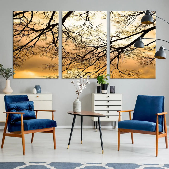 The Tree Branch Wall Art Canvas Print is a triptych depicting tree branches against an orange sky, printed on museum-quality canvases. Each piece comes ready to hang, offering both style and convenience.