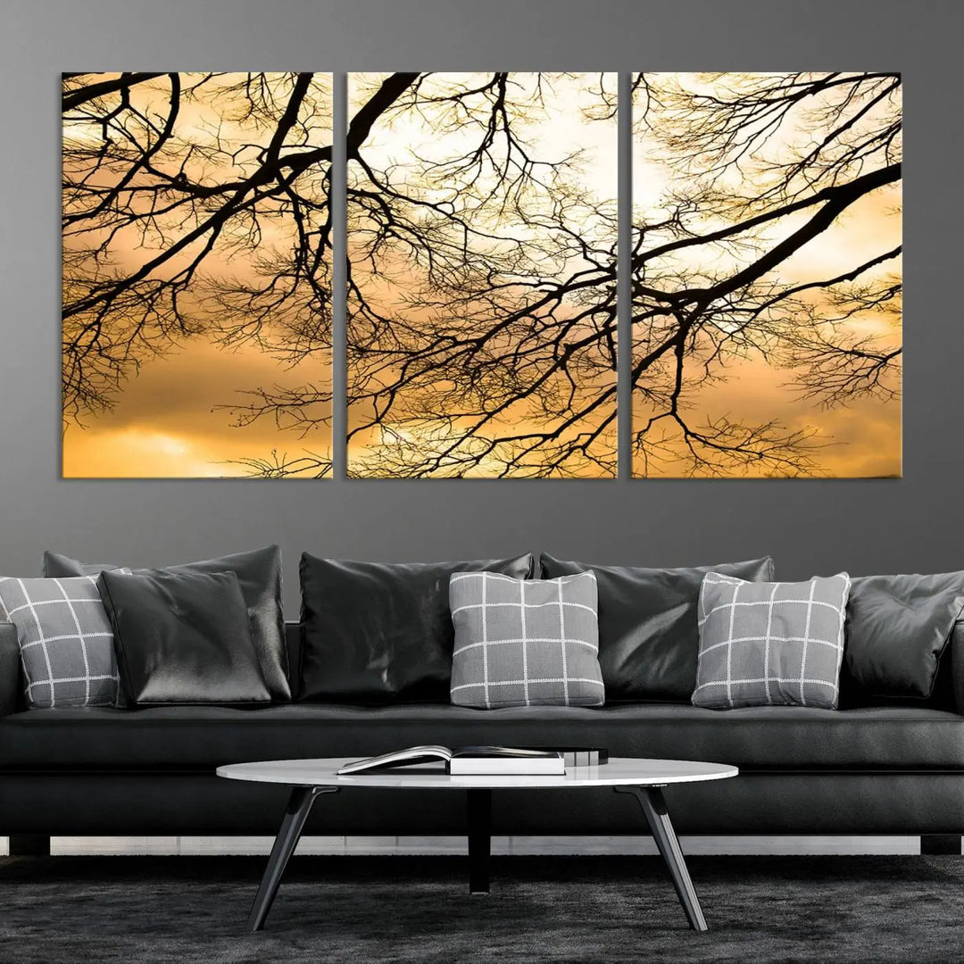 The Tree Branch Wall Art Canvas Print is a triptych depicting tree branches against an orange sky, printed on museum-quality canvases. Each piece comes ready to hang, offering both style and convenience.