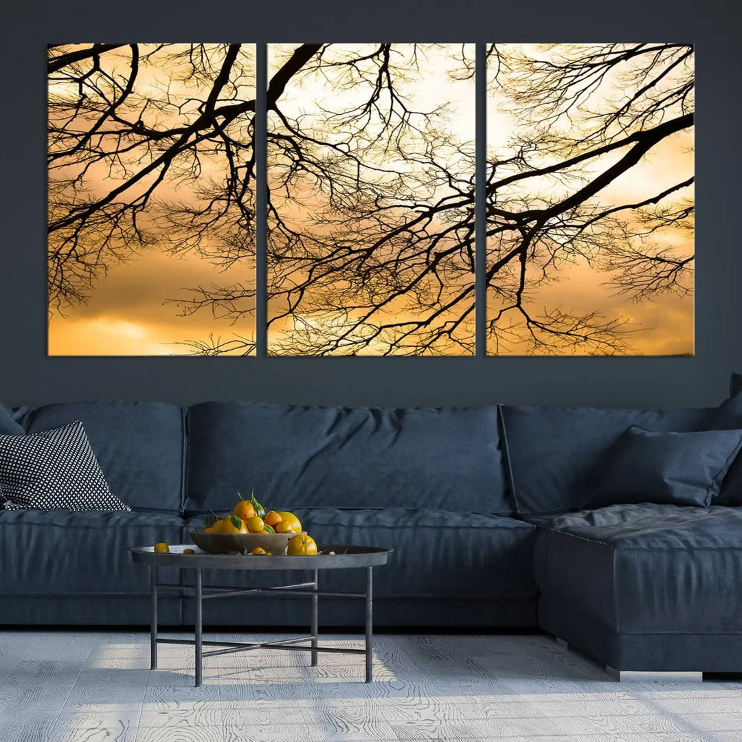 The Tree Branch Wall Art Canvas Print is a triptych depicting tree branches against an orange sky, printed on museum-quality canvases. Each piece comes ready to hang, offering both style and convenience.