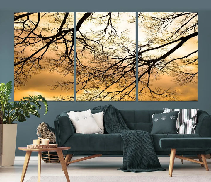 The Tree Branch Wall Art Canvas Print is a triptych depicting tree branches against an orange sky, printed on museum-quality canvases. Each piece comes ready to hang, offering both style and convenience.