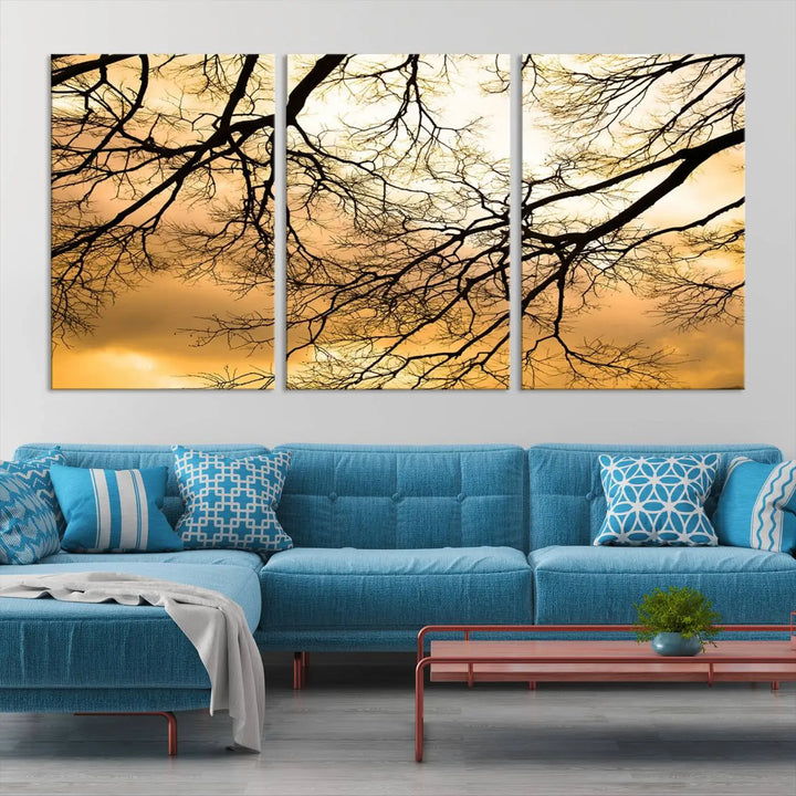 The Tree Branch Wall Art Canvas Print is a triptych depicting tree branches against an orange sky, printed on museum-quality canvases. Each piece comes ready to hang, offering both style and convenience.