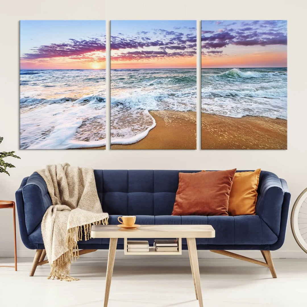 A triptych canvas wall art featuring the Tropical Beach Waves Art Print with a sunset ocean seascape adds striking beauty and perfectly complements the modern living room’s coastal decor.