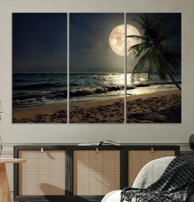 The Tropical Beach and Moon Wall Art Canvas Print features a stunning three-panel artwork of a moonlit beach, complete with waves and a palm tree beneath a starry night sky. It is displayed on museum-quality canvas with an elegant gallery wrap and includes a UV-protective coating for enduring beauty.