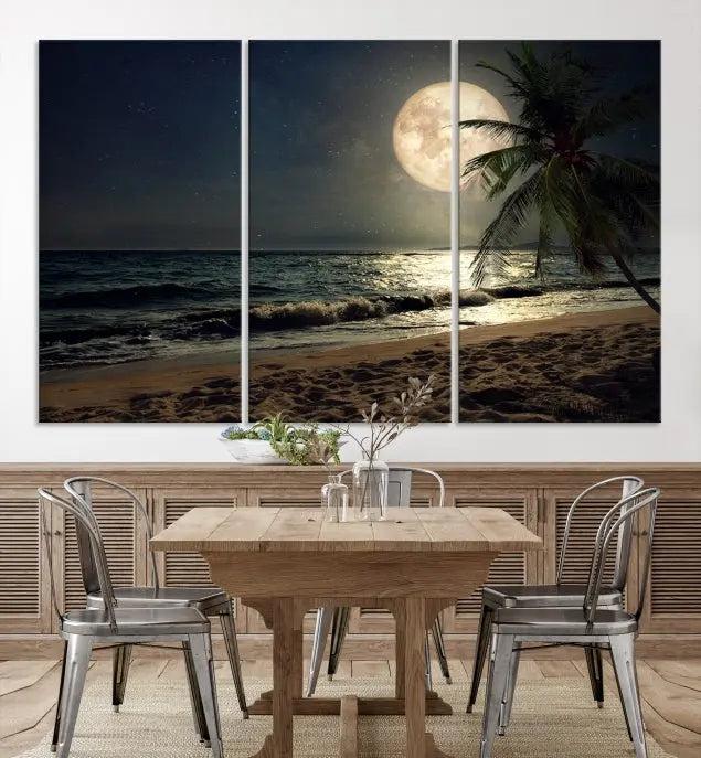 The Tropical Beach and Moon Wall Art Canvas Print features a stunning three-panel artwork of a moonlit beach, complete with waves and a palm tree beneath a starry night sky. It is displayed on museum-quality canvas with an elegant gallery wrap and includes a UV-protective coating for enduring beauty.