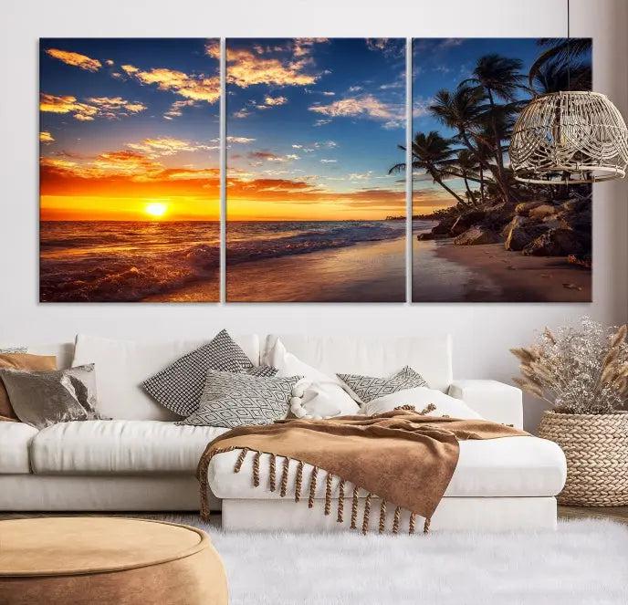 A living room featuring the Tropical Island Wall Art Canvas Print Sunset Artwork Print, a triptych displaying a beach sunset on museum-quality canvas with UV-protective coating, is prepared to hang.