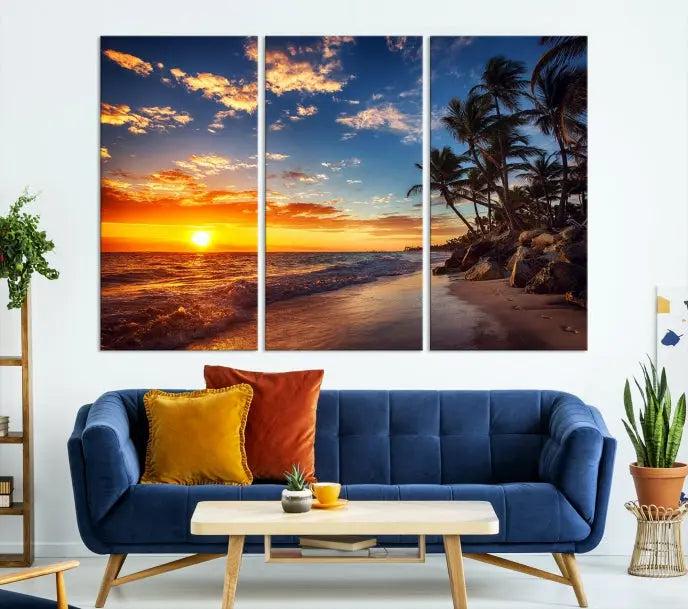 A living room featuring the Tropical Island Wall Art Canvas Print Sunset Artwork Print, a triptych displaying a beach sunset on museum-quality canvas with UV-protective coating, is prepared to hang.