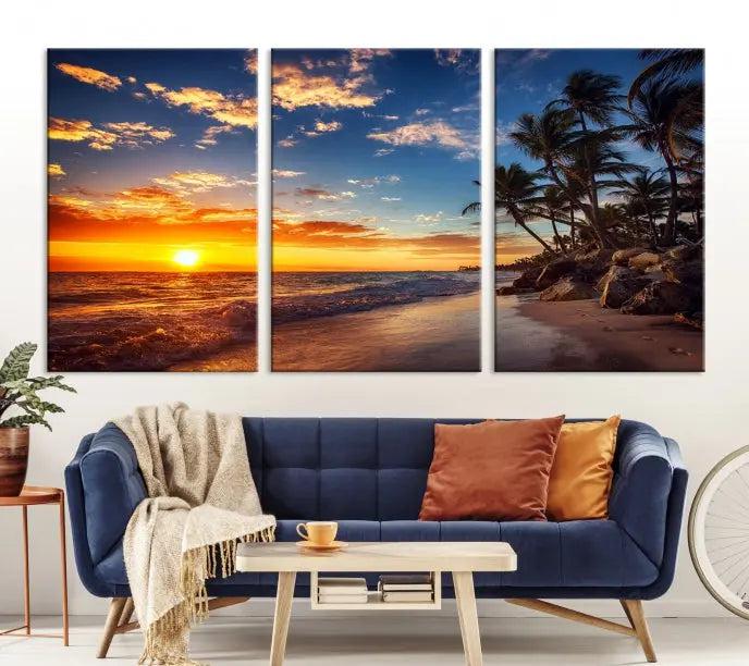 A living room featuring the Tropical Island Wall Art Canvas Print Sunset Artwork Print, a triptych displaying a beach sunset on museum-quality canvas with UV-protective coating, is prepared to hang.