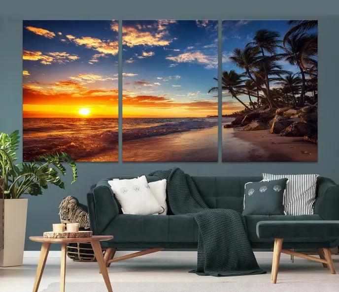 A living room featuring the Tropical Island Wall Art Canvas Print Sunset Artwork Print, a triptych displaying a beach sunset on museum-quality canvas with UV-protective coating, is prepared to hang.