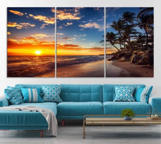 A living room featuring the Tropical Island Wall Art Canvas Print Sunset Artwork Print, a triptych displaying a beach sunset on museum-quality canvas with UV-protective coating, is prepared to hang.