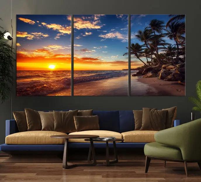 A living room featuring the Tropical Island Wall Art Canvas Print Sunset Artwork Print, a triptych displaying a beach sunset on museum-quality canvas with UV-protective coating, is prepared to hang.