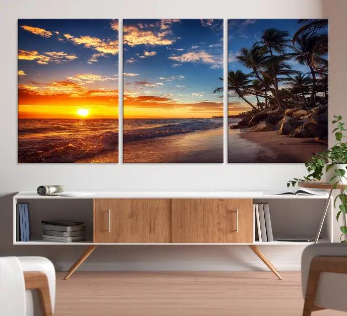 A living room featuring the Tropical Island Wall Art Canvas Print Sunset Artwork Print, a triptych displaying a beach sunset on museum-quality canvas with UV-protective coating, is prepared to hang.