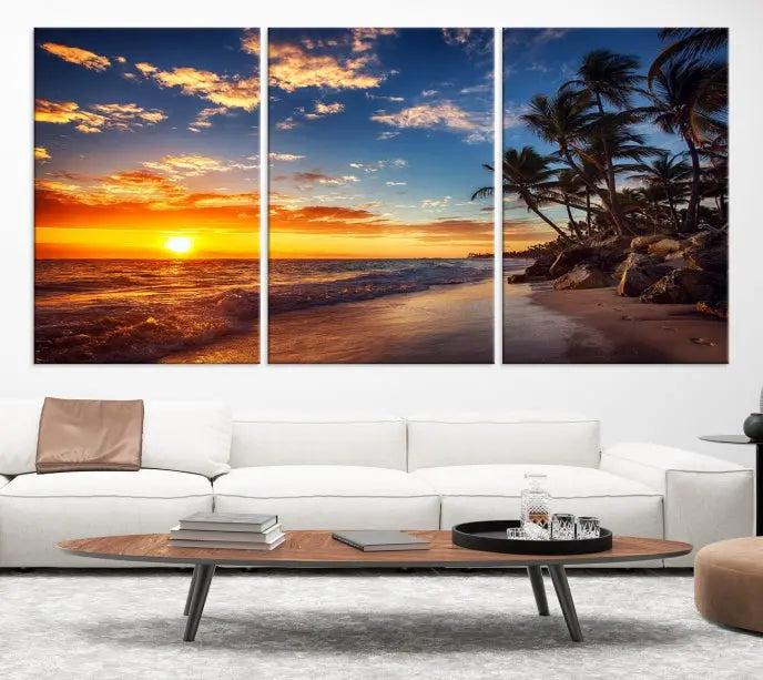 A living room featuring the Tropical Island Wall Art Canvas Print Sunset Artwork Print, a triptych displaying a beach sunset on museum-quality canvas with UV-protective coating, is prepared to hang.